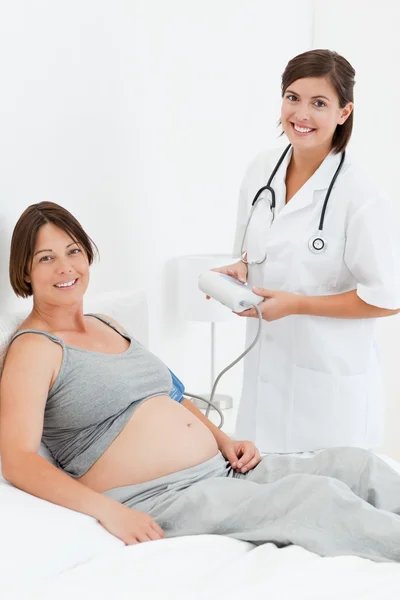 Gravid kvinna med en sjuksköterska-smilling — Stockfoto