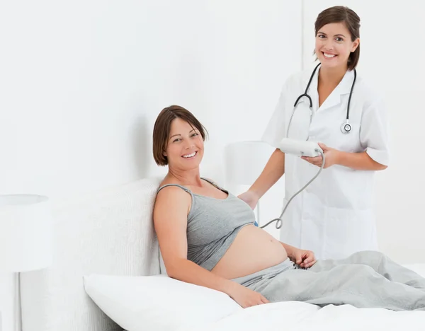 Pregnant woman with a nurse smilling — Stock Photo, Image