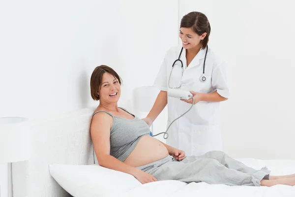 Mujer embarazada con una enfermera oliendo — Foto de Stock
