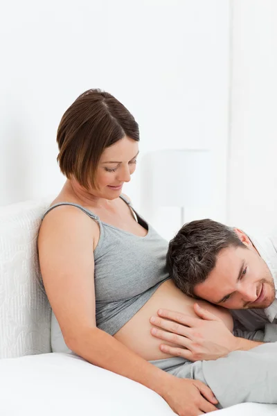 Mąż słucha jego żona brzuch — Zdjęcie stockowe