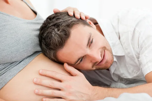 Husband listening to his wife's belly — Stock Photo, Image