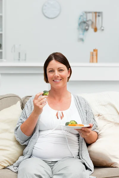 Těhotná žena jíst zeleninu — Stock fotografie