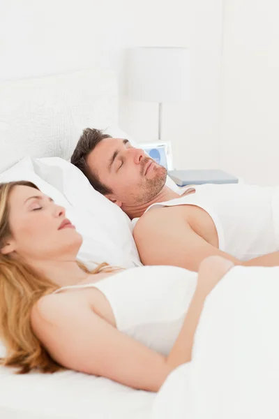 Lyckliga par i sin säng — Stockfoto
