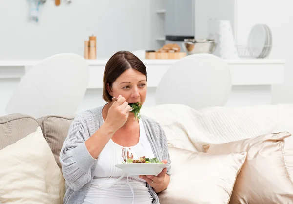 Femme enceinte mangeant des légumes — Photo