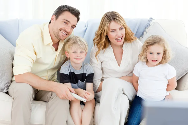 Okouzlující rodina dívat na televizi — Stock fotografie