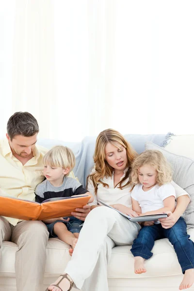 Rodina čtení knihy na své pohovce — Stock fotografie