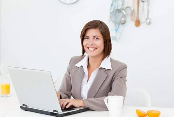 Uśmiechnięta kobieta pracuje na jej laptopie — Zdjęcie stockowe