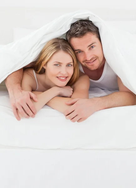 Krásný pár objímat v jejich posteli — Stock fotografie