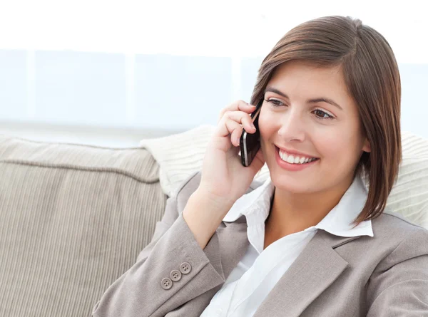 Smilng zakenvrouw bellen op haar bank — Stockfoto