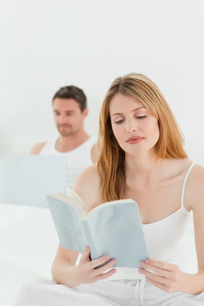El hombre está en su portátil mientras su esposa está leyendo un libro — Foto de Stock
