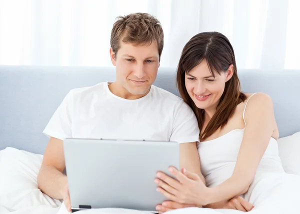 Молодая пара смотрит видео на своем компьютере дома — стоковое фото