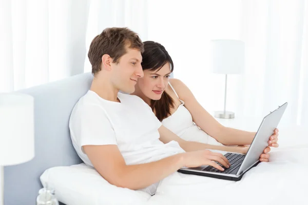 年轻的夫妇看他们在家里的电脑上的视频 — 图库照片