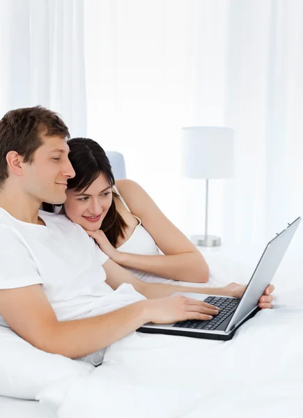Νεαρό ζευγάρι, βλέποντας το βίντεο στον υπολογιστή τους στο σπίτι — Φωτογραφία Αρχείου