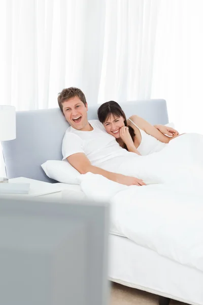 Casal assistindo tv em sua cama — Fotografia de Stock