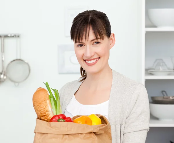 Kvinna med shoping väskor i köket — Stockfoto
