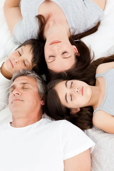 Семья лежит на кровати — стоковое фото