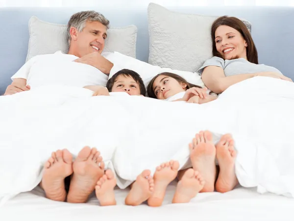 Familjen liggande i sin säng — Stockfoto