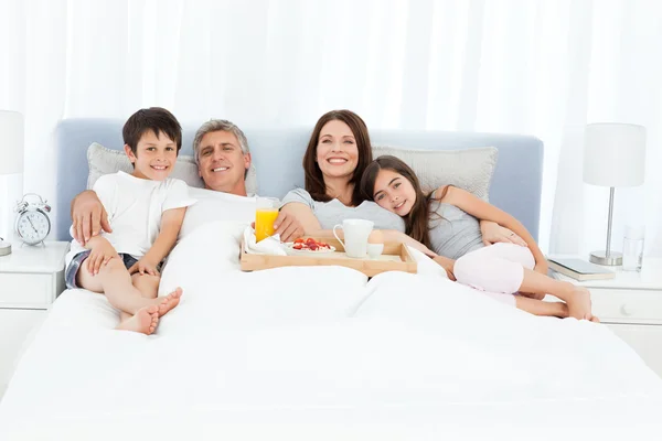 Aile onların yatakta kahvaltı — Stok fotoğraf