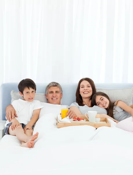 彼らのベッドで朝食を持っている家族 — ストック写真