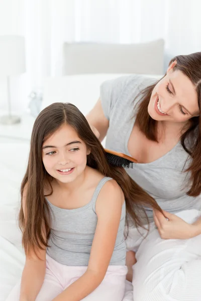 Mulher escovando seu cabelo filha — Fotografia de Stock