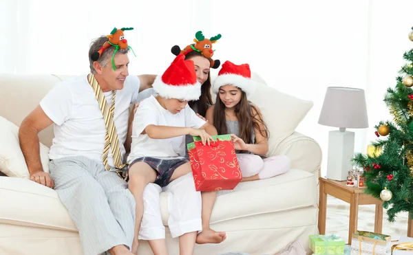 Família durante o dia de Natal olhando para seus presentes — Fotografia de Stock