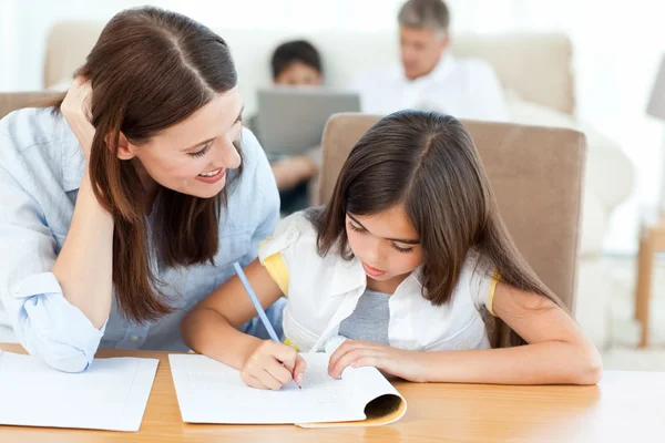 Moeder haar dochter voor haar huiswerk helpen — Stockfoto