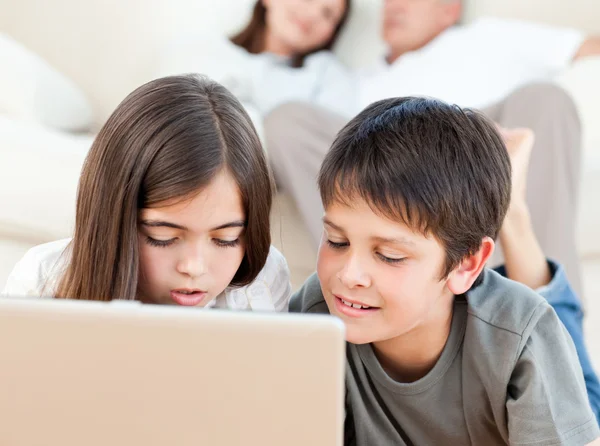 Niños encantadores viendo una película en su computadora portátil en casa — Foto de Stock