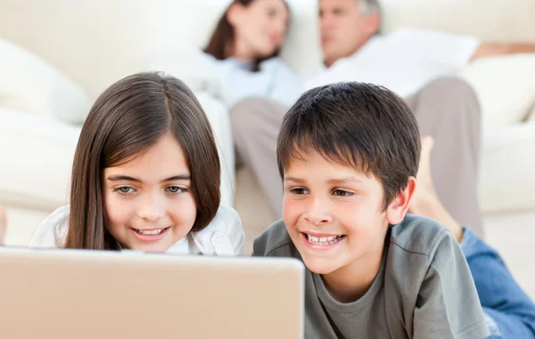 Härliga barn tittar på en film på sin laptop hemma — Stockfoto
