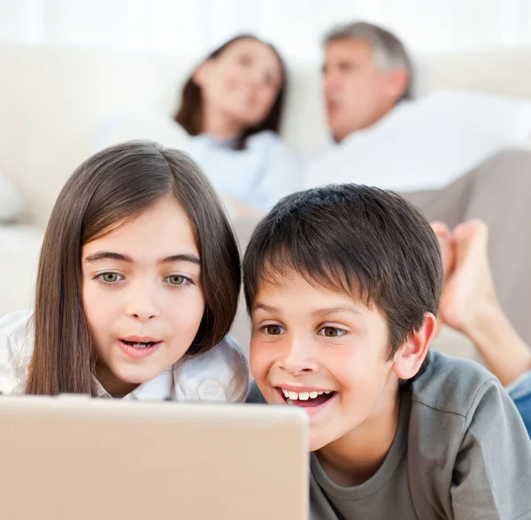 Niños encantadores viendo una película en su computadora portátil en casa —  Fotos de Stock