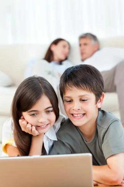 Niños encantadores viendo una película en su computadora portátil en casa —  Fotos de Stock