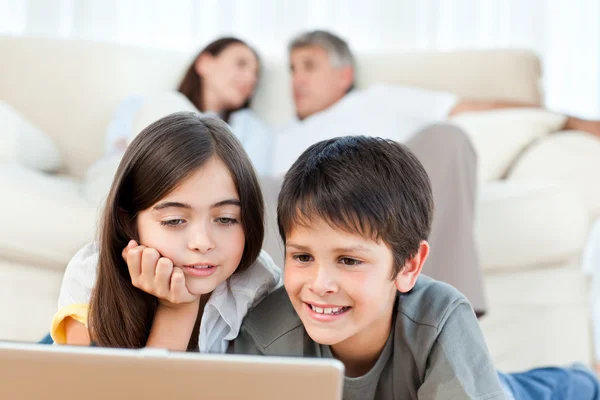 Niños encantadores viendo una película en su computadora portátil en casa — Foto de Stock