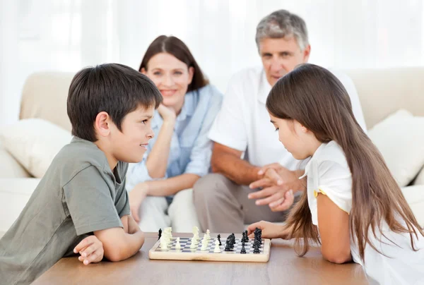 Eltern schauen ihren Kindern beim Schachspielen zu — Stockfoto