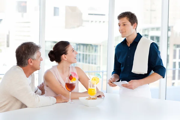 Ouder paar met een ober in een bar — Stockfoto