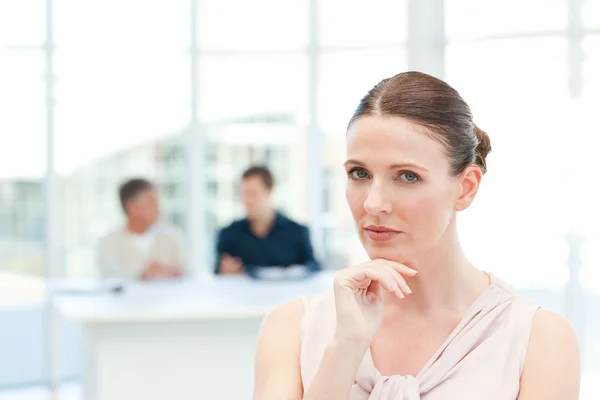 Serious businesswoman looking at the camera while her coworkers — Stock Photo, Image