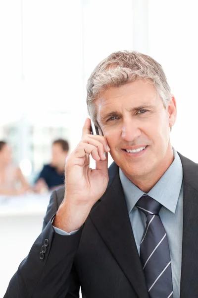 Businessman phoning while his team is working — Stock Photo, Image