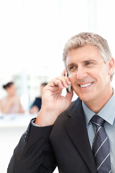 Businessman phoning while his team is working — Stock Photo, Image