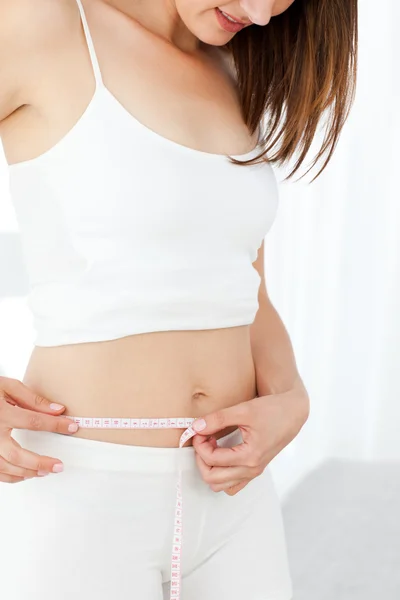 Woman looking at her waistline — Stock Photo, Image