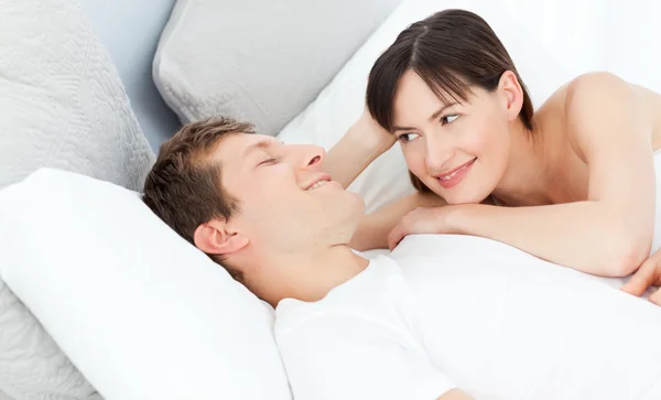 Glückliches Paar legt sich zusammen auf sein Bett — Stockfoto