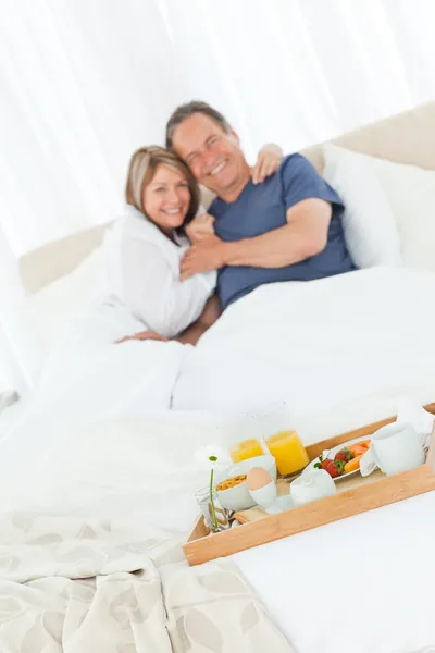 Adorável casal tomando café da manhã em sua cama — Fotografia de Stock