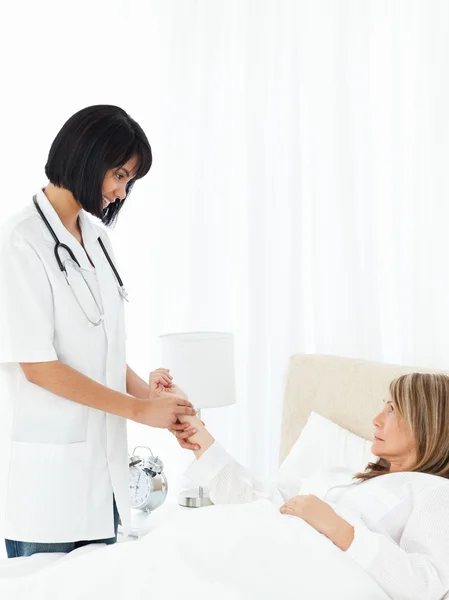 Nurse taking the pulse of her patient — Stock Photo, Image