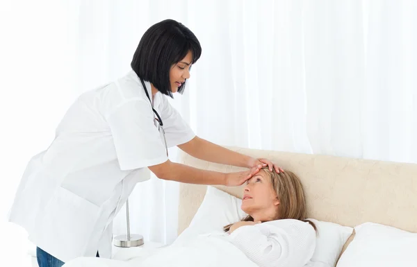 Sjuksköterska tar temperaturen av hennes patient — Stockfoto