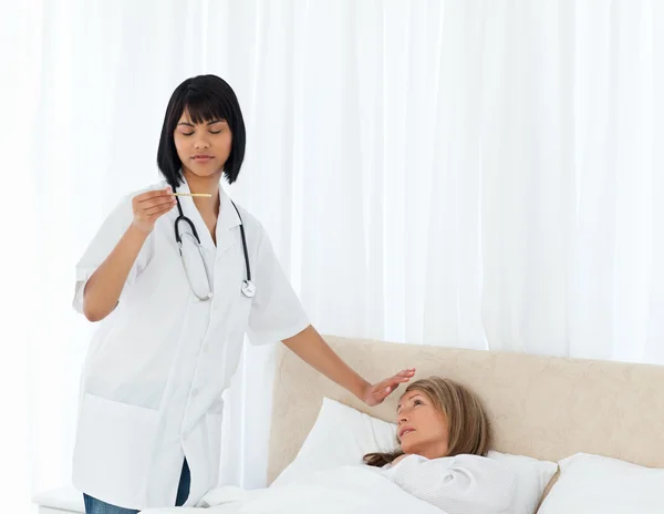 Медсестра измеряет температуру своего пациента — стоковое фото