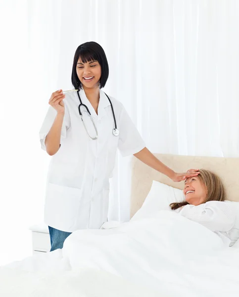 Sjuksköterska tar temperaturen av hennes patient — Stockfoto