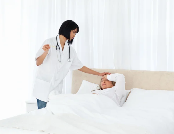 Enfermeira tomando a temperatura de seu paciente — Fotografia de Stock