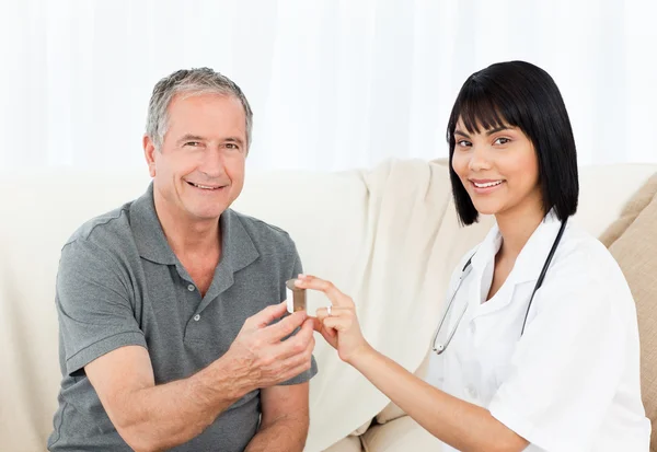 Retired man with his nurse looking at the camera — Stock Photo, Image