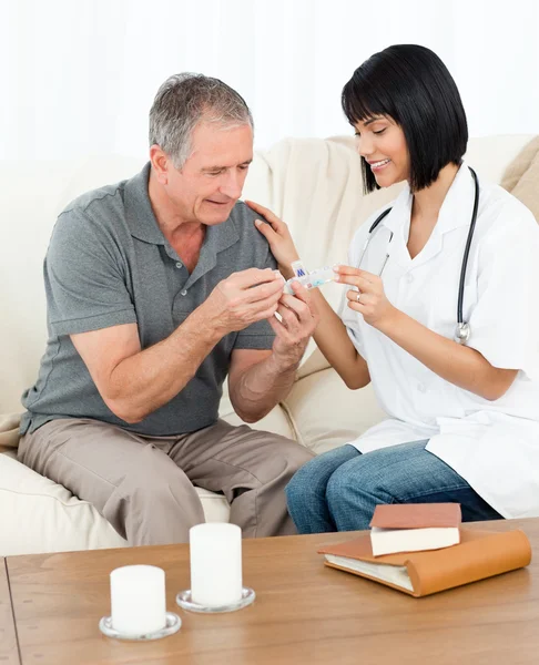 Медсестра показывает таблетки своему пациенту — стоковое фото