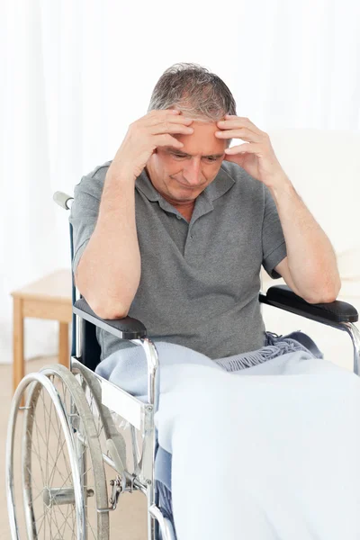 Senior dans son fauteuil roulant ayant mal à la tête — Photo