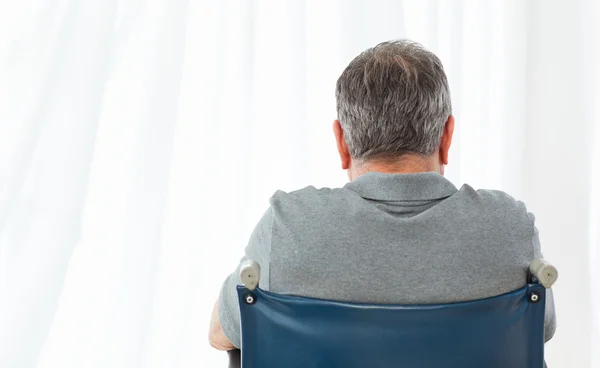 Зрелый мужчина в инвалидном кресле спиной к камере — стоковое фото