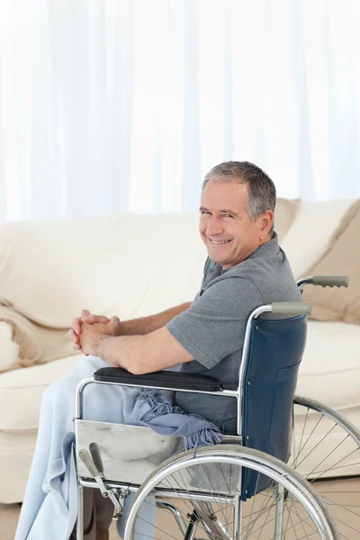 Mature homme dans son fauteuil roulant regardant la caméra — Photo