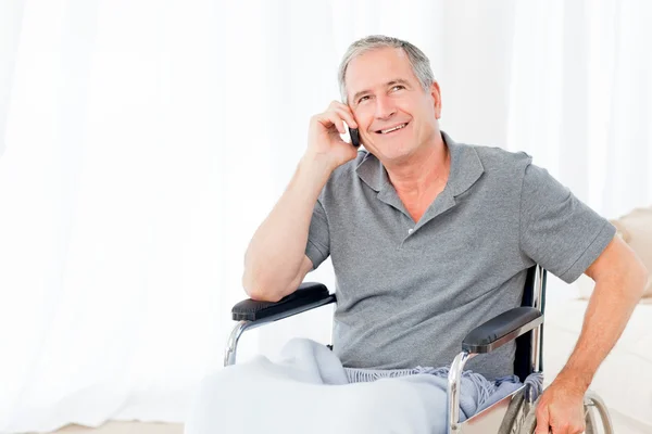 Senior en su silla de ruedas telefoneando — Foto de Stock
